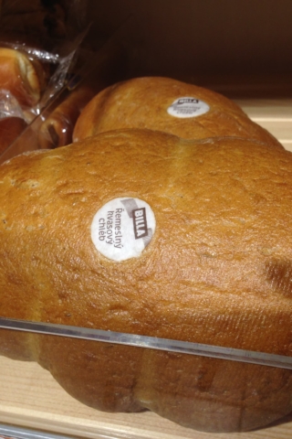 Chléb označený jedlou etiketou BILLA v regálu